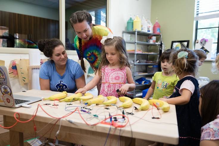 Students work with children on a banana piano in Rollins’ Child Development Center.
