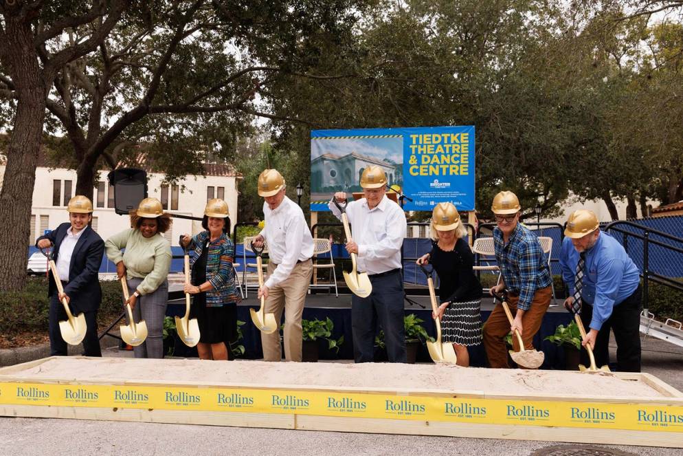 Students, faculty, staff, and trustees weird golden shoves as they break ground on the new theatre and dance complex