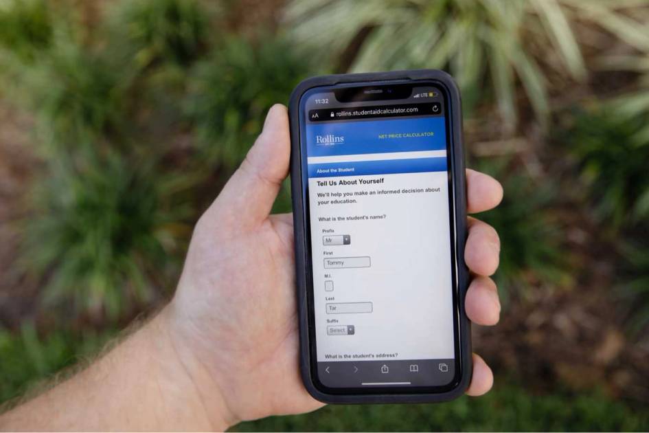 A photo of a hand holding a phone with Rollins’ net price calculator on the screen.