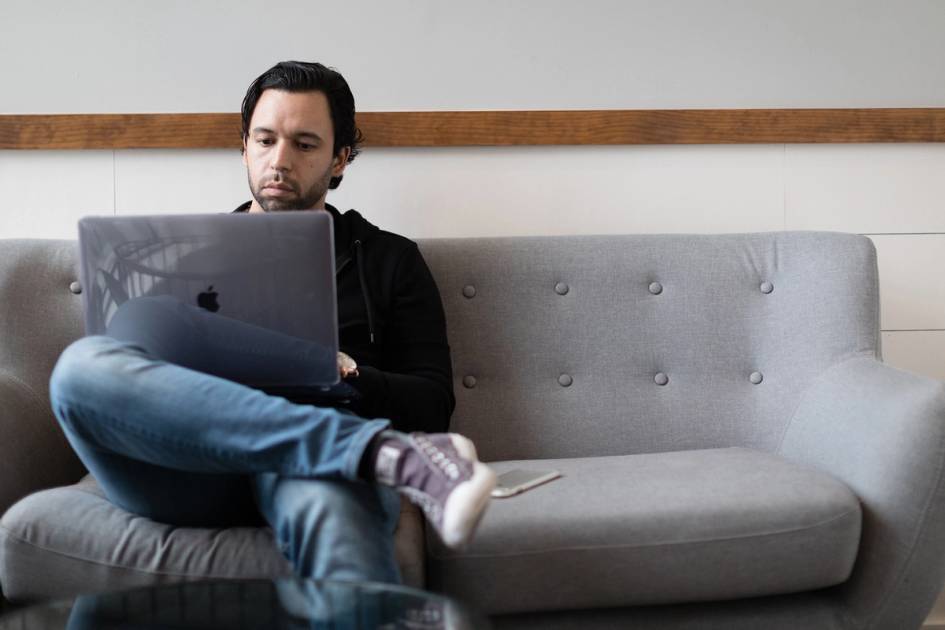 A man works on his laptop in a coffee shop.