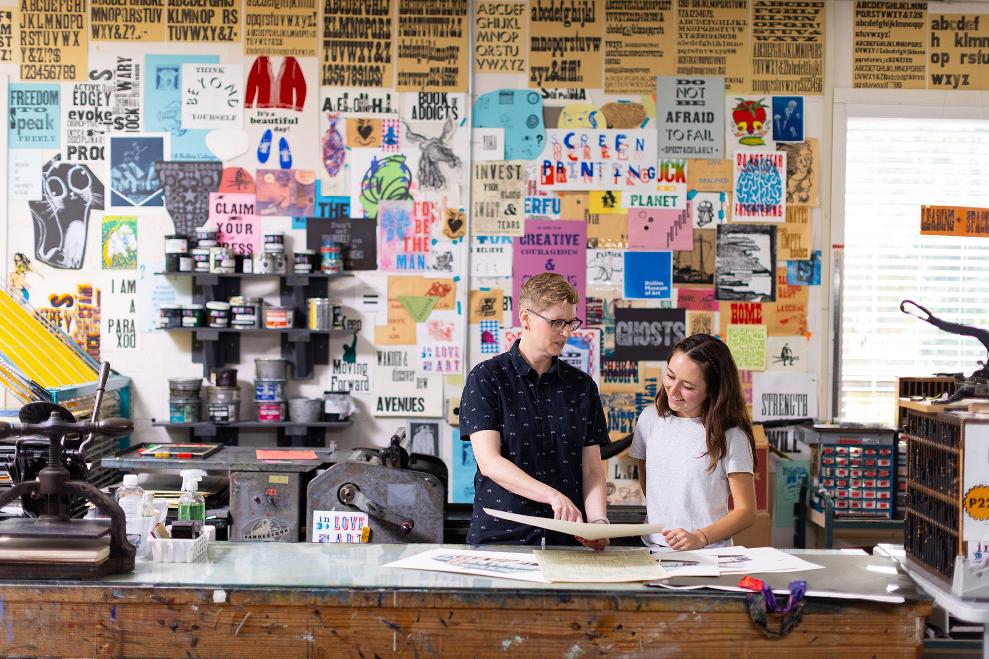 A studio art professor provides a student with feedback on her designs.