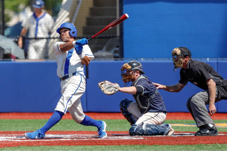 A baseball player swinging in the batter's box.