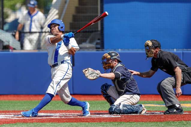 An athlete hitting a baseball in a game.