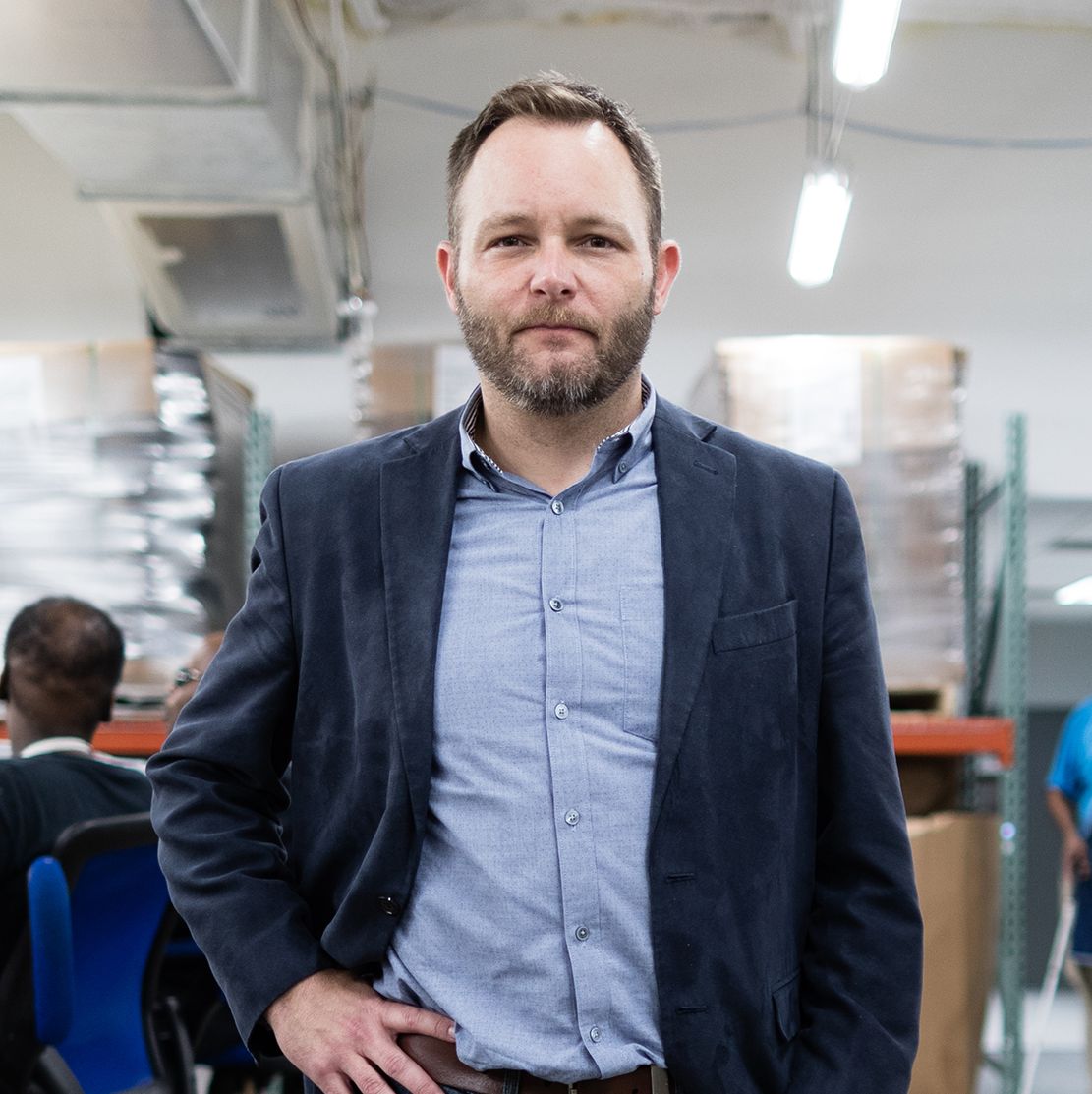 A portrait of Kyle Johnson standing in the Lighthouse Central Florida warehouse.