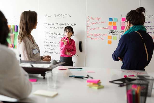 Students brainstorming on a whiteboard in the Social Impact Hub.