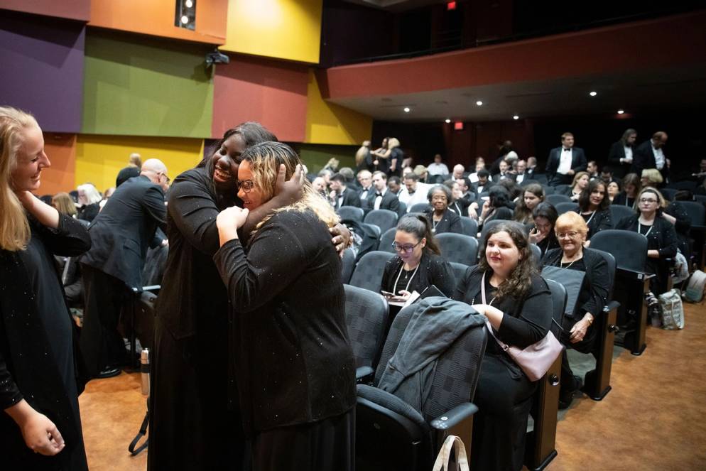 Chadonné Whiskey ’20 hugs a friend after singing in the Bach Festival holiday concert.