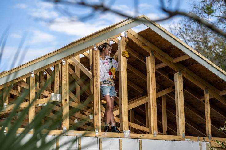 A student helps build a house for Habitat for Humanity. 