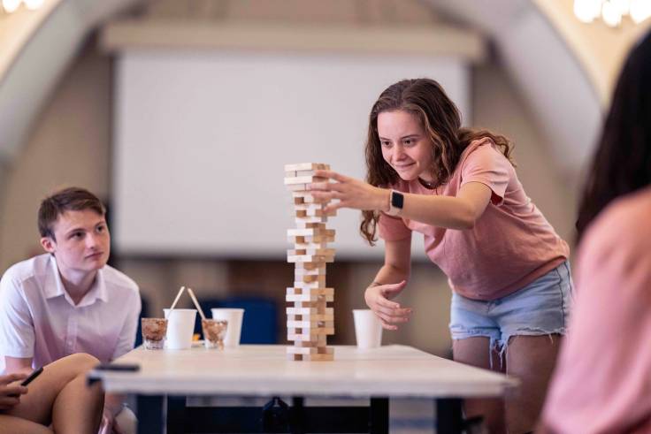 Dani Golob ’24 tries her hand at Jenga during an EMBARK event over Family Weekend.