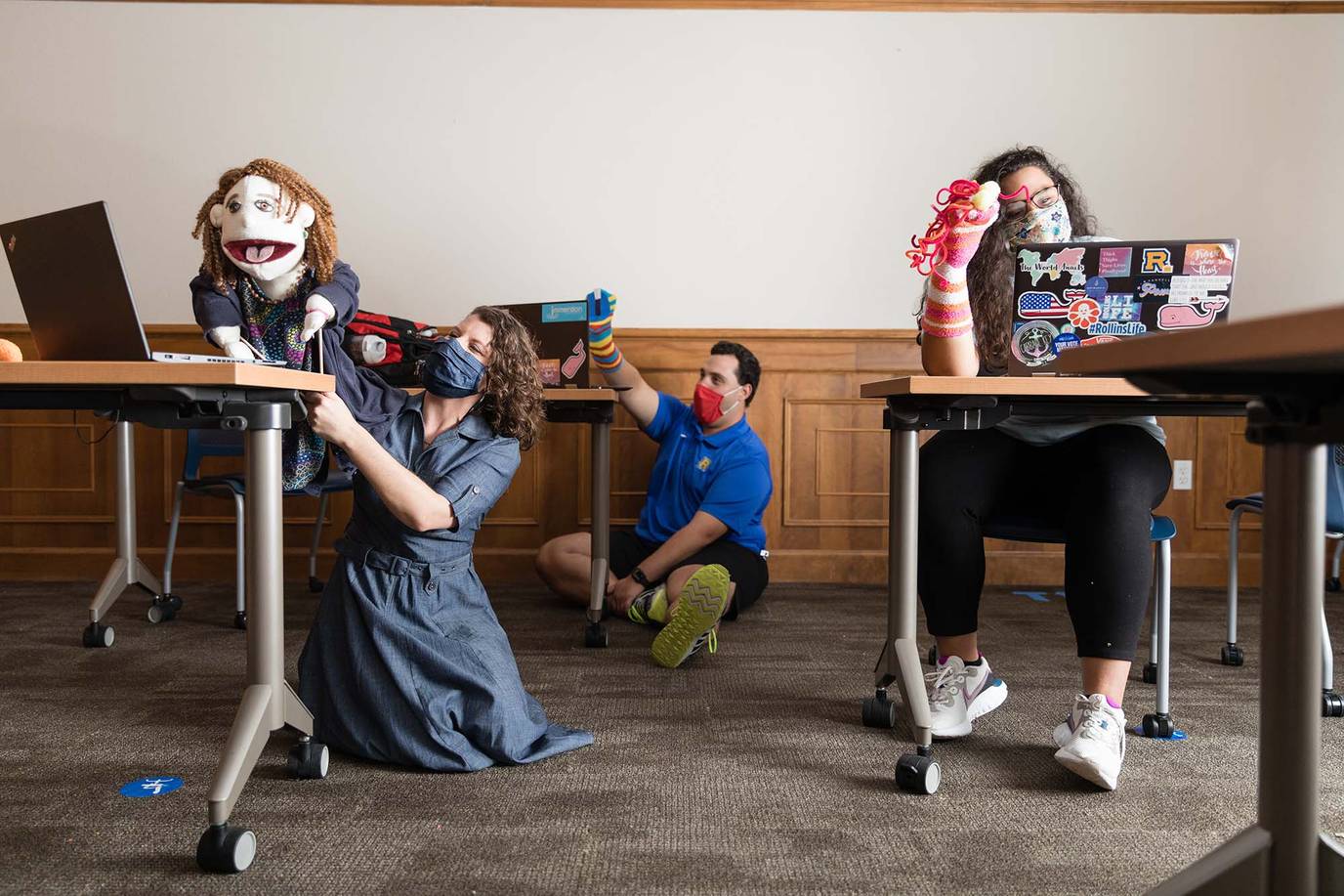 Students hold puppets during an online workshop. 