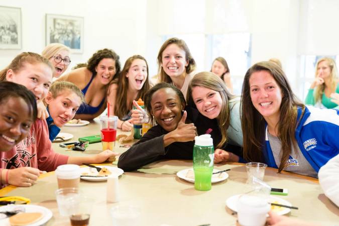 A group of students crowd around a table for breakfast on Fox Day.