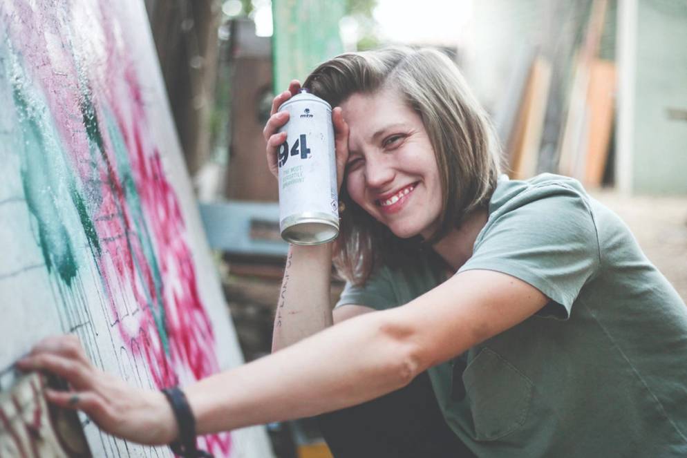 Grace Loescher ’14 spray paints a mural in California