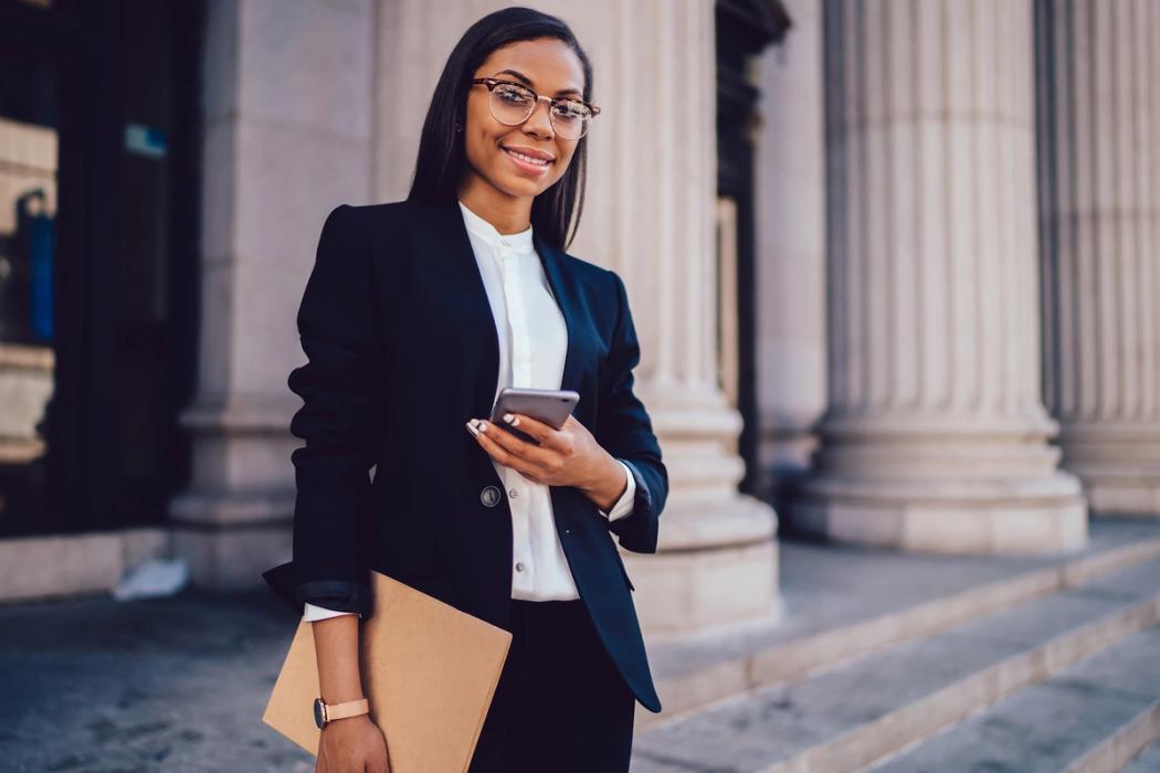 Student intern posing with phone and folder