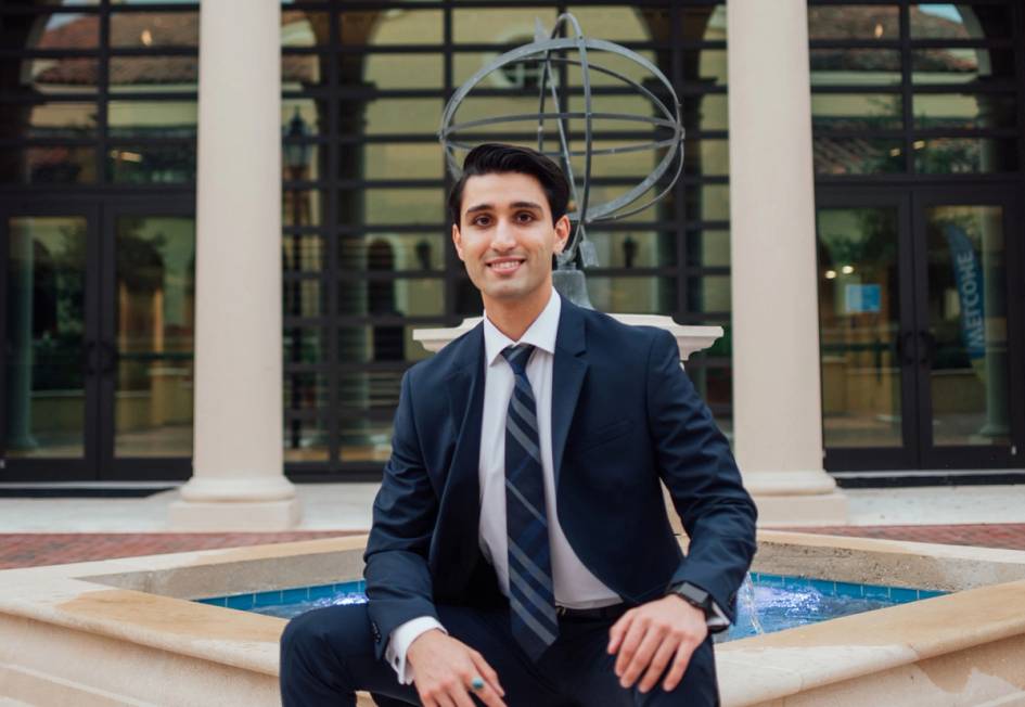 A Rollins student poses in a suit while on campus. 