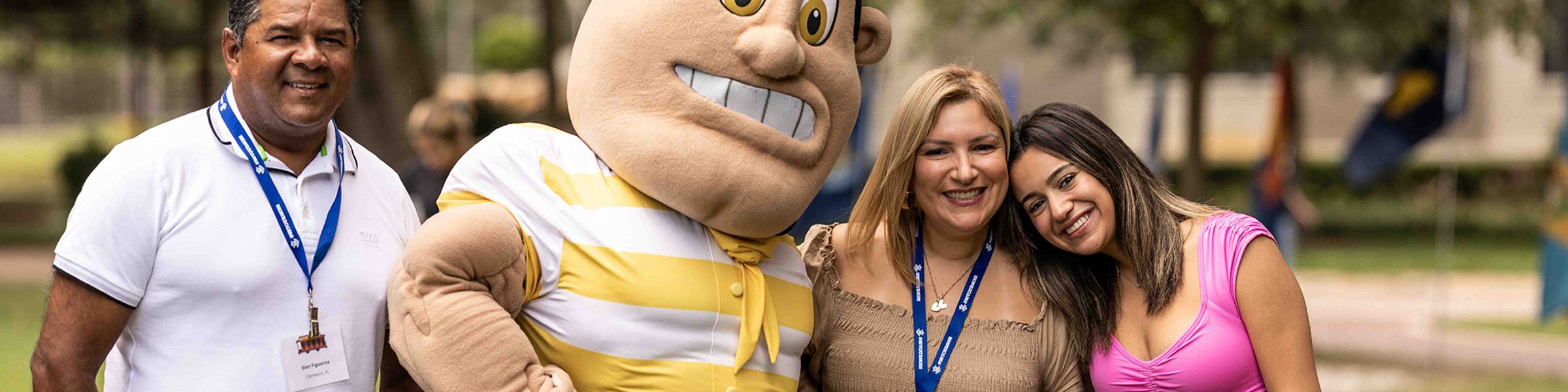 Two Rollins parents pose with their student and Tommy Tar, the Rollins mascot, at Family Weekend.