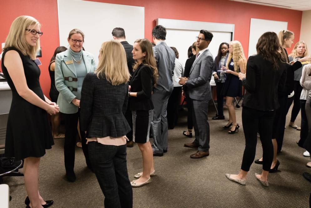 A group of sharp dressed business students networking.