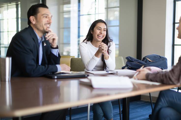 A business advisor meets with a pair of students.