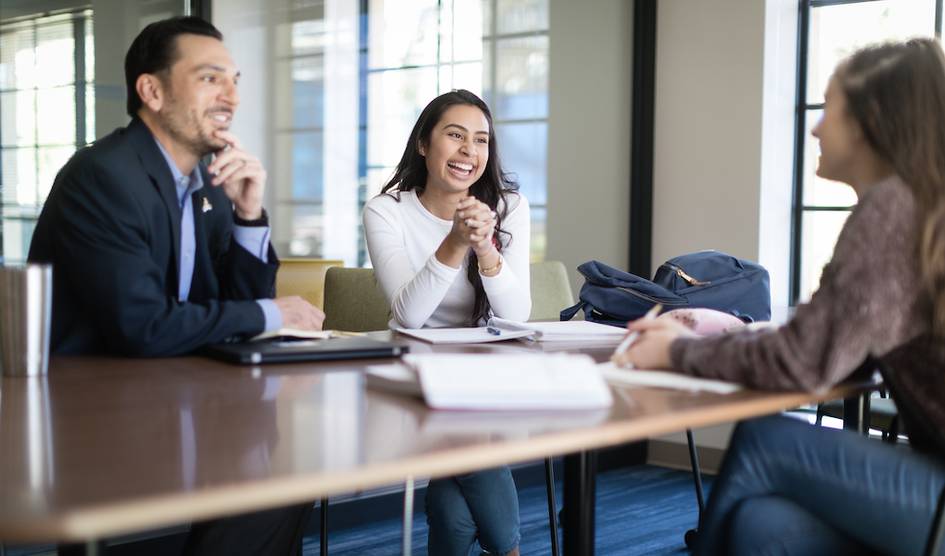 A business advisor meets with a pair of students.