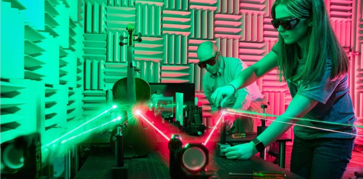 student and a professor work on a laser project together