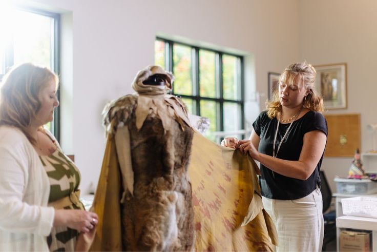 Theatre professor Allison Crutchfield and Alex Collins ’29 examine a large fur and fabric costume in studio.