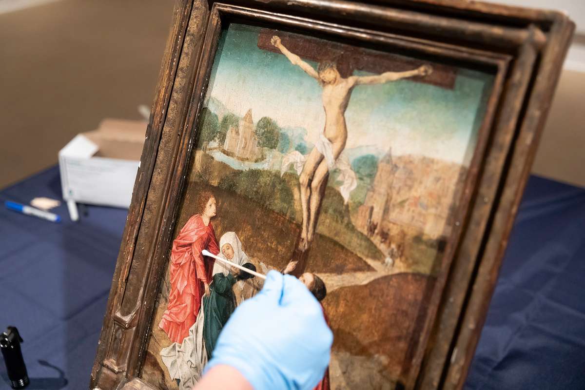 Student restoring an old painting from the Cornell Fine Arts Museum.