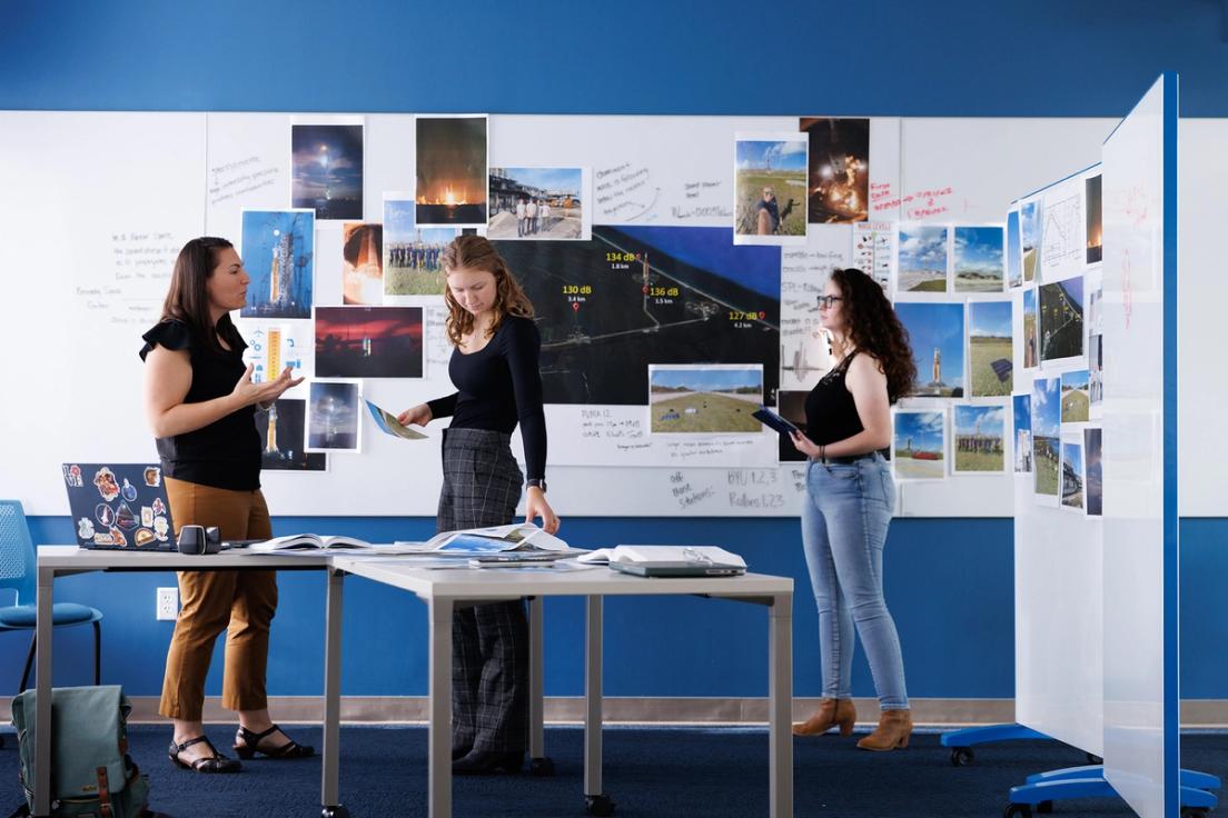 Physics professor Whitney Coyle with Rollins students working on Artemis rocket research