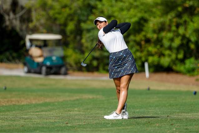 A female golfer finishing in her backswing.