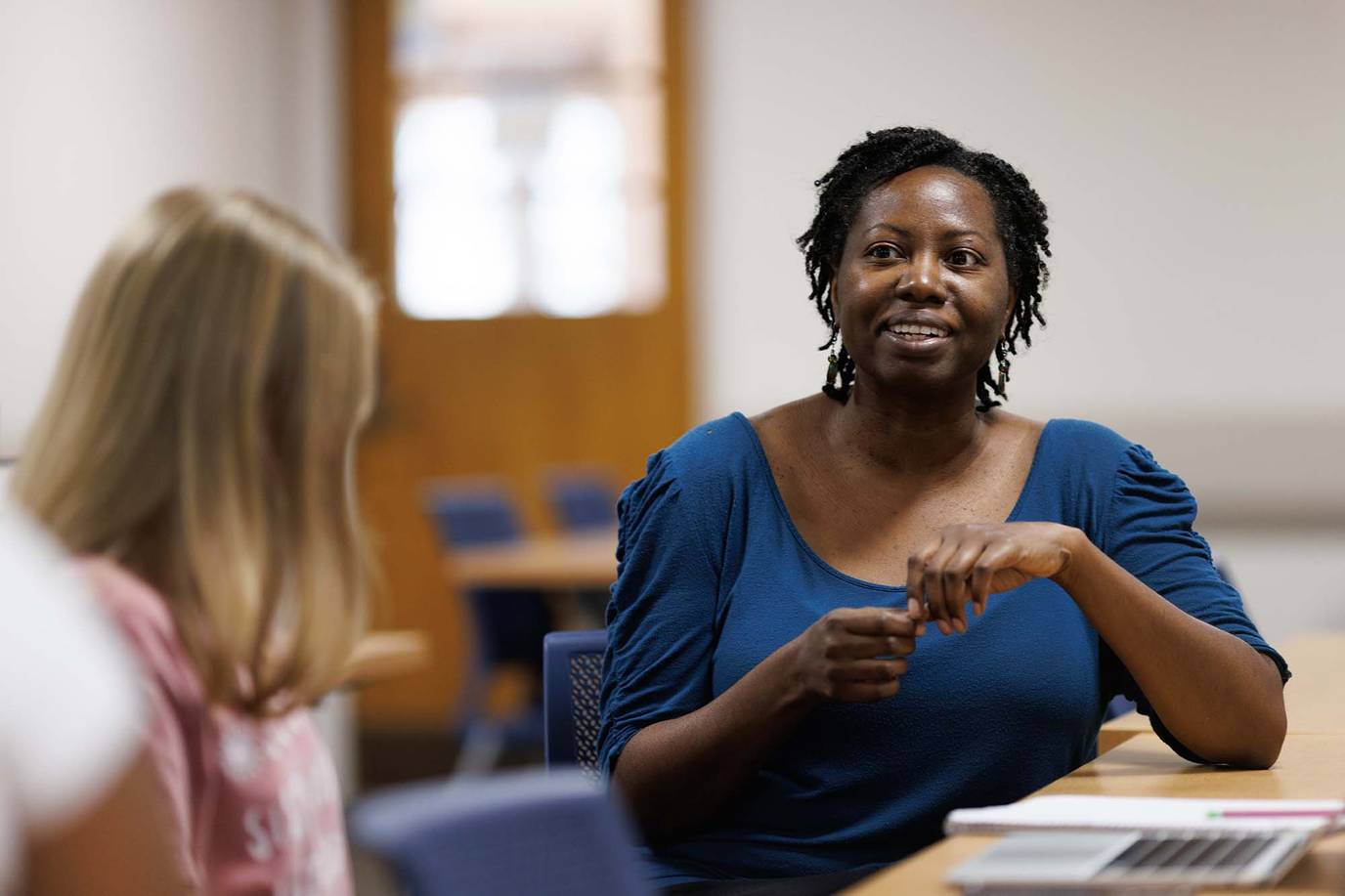 Shan-Estelle Brown speaks with a student during a class session.