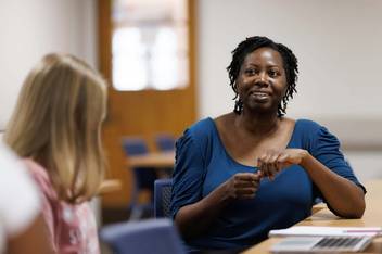Shan-Estelle Brown speaks with a student during a class session.