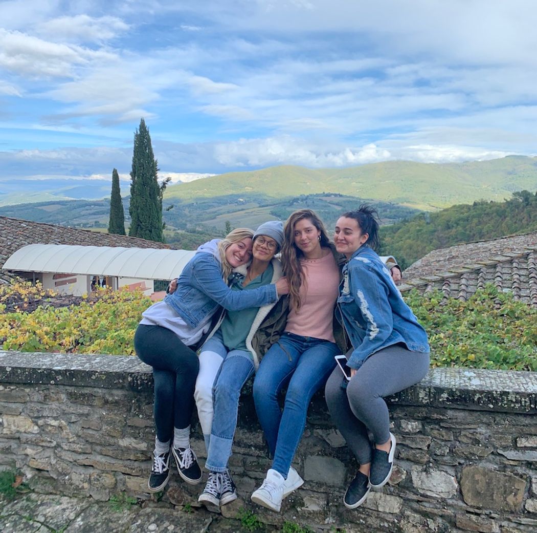 Students on a fence overlooking the Italian countryside.