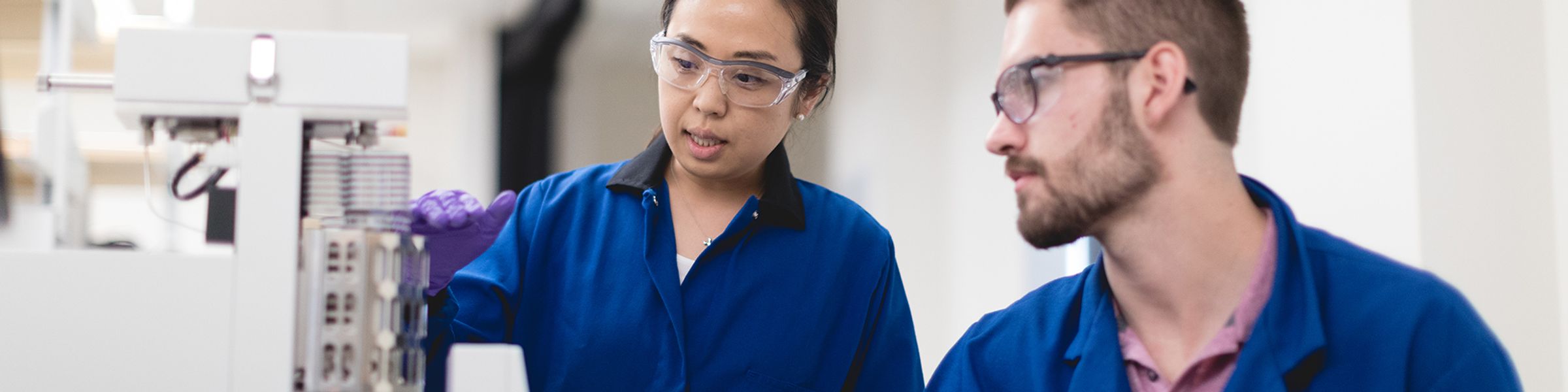 Chemistry students handling chemicals in a lab.