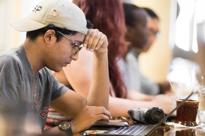 Student working on laptop at Downtown Credo, a local coffee shop.