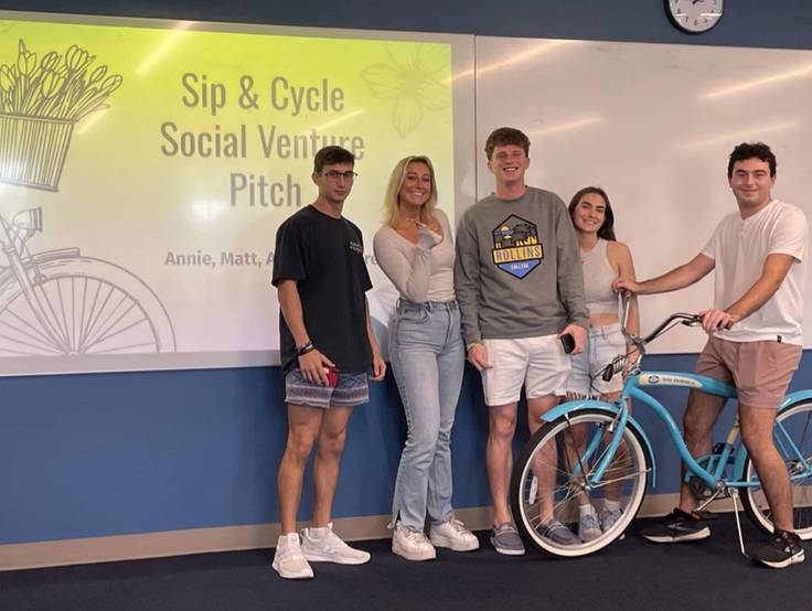 Group of social entrepreneurship students in a classroom pitching a social venture