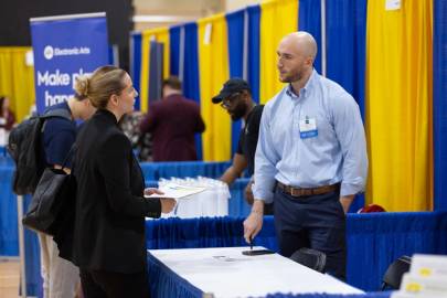 Student and alumnus conversing during a career networking event on campus.