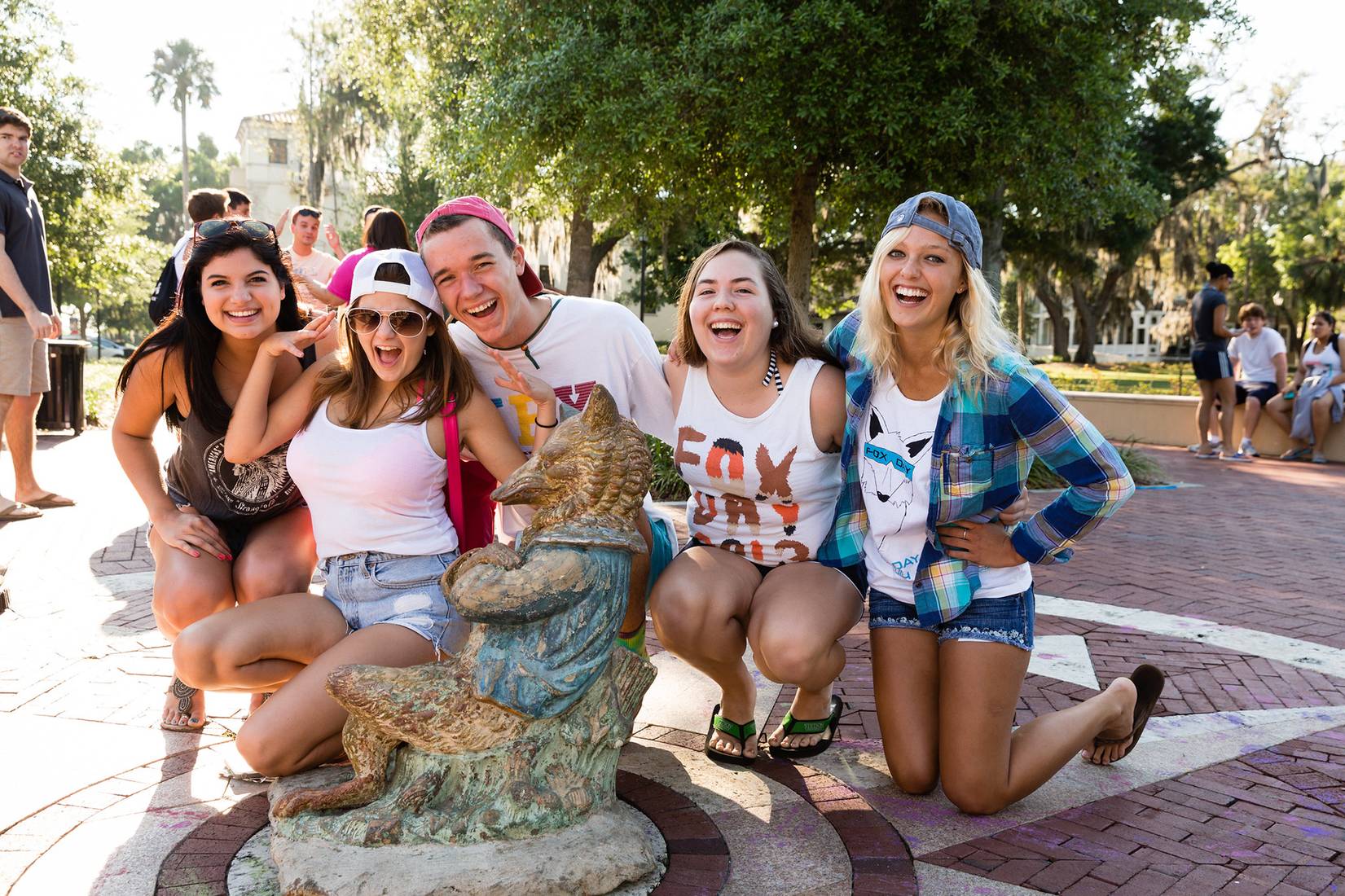 Five students pose with the fox statue on Fox Day.