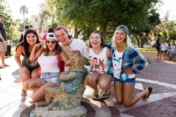 Five students pose with the fox statue on Fox Day.