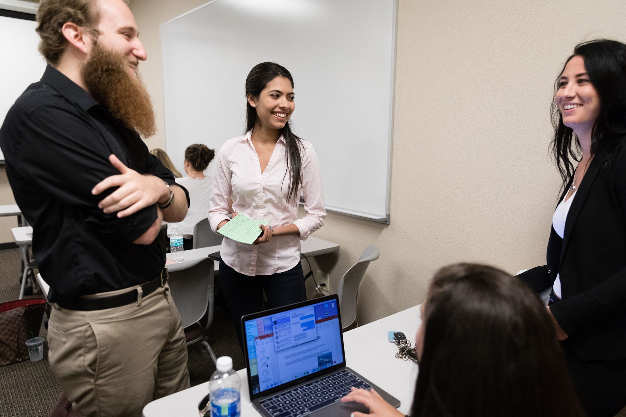 Four students collaborate on a business management project.