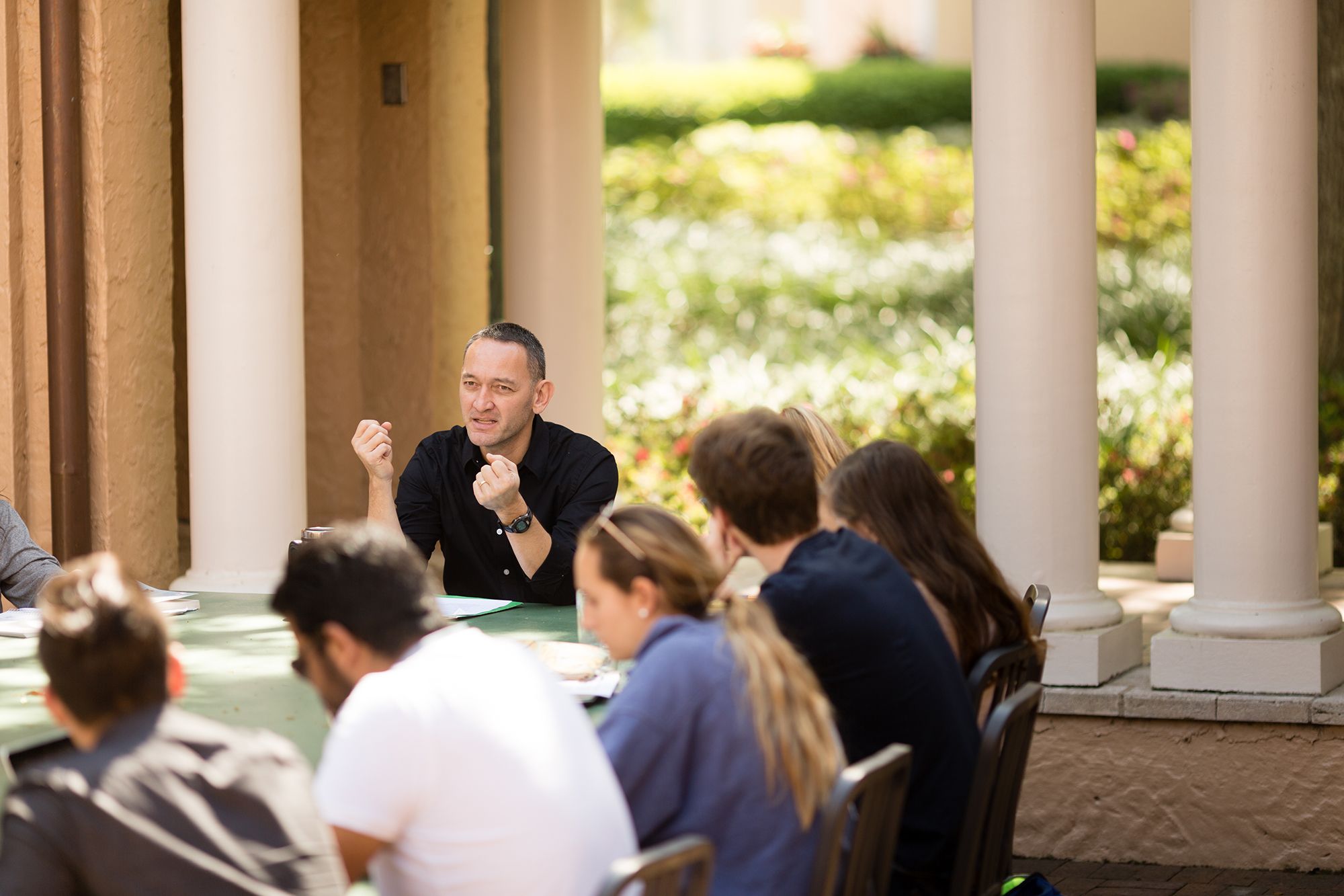 Professor and students in a class discussion at a Rollins outdoor classroom