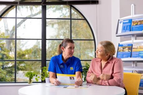 A Rolllins graduate admission counselor in a blue Rollins polo meets one-on-one with a prospective student.