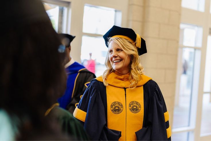 Smiling President Brooke Barnett in academic regalia during inauguration ceremony.