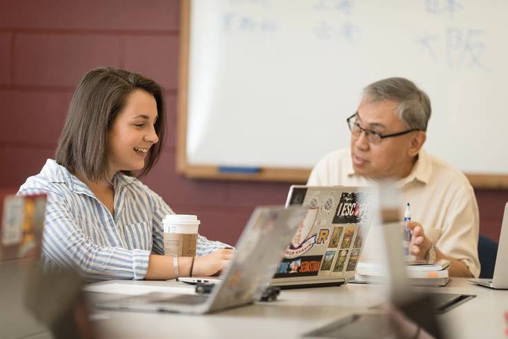 A Rollins student and professor work closely together in class.