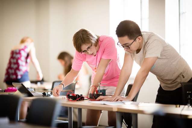 A couple of physics students working on an experiment in a laboratory.