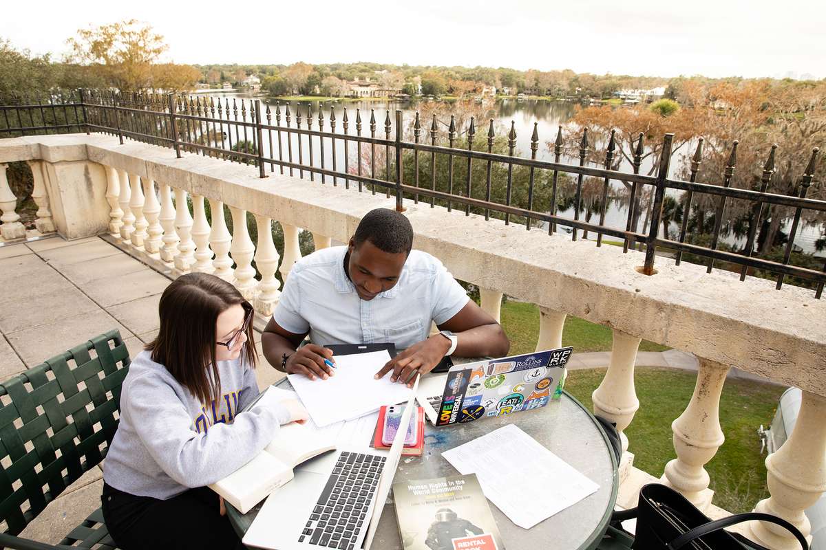 Students studying on the balcony of Ward Hall, which overlooks Lake Virginia.