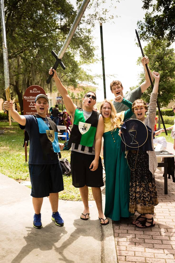 Professor, Jana Matthew, and students dressed in medieval attire holding up their swords and shields.