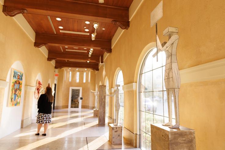 A student exploring the Ally Is a Verb exhibition at the Rollins Museum of Art. 