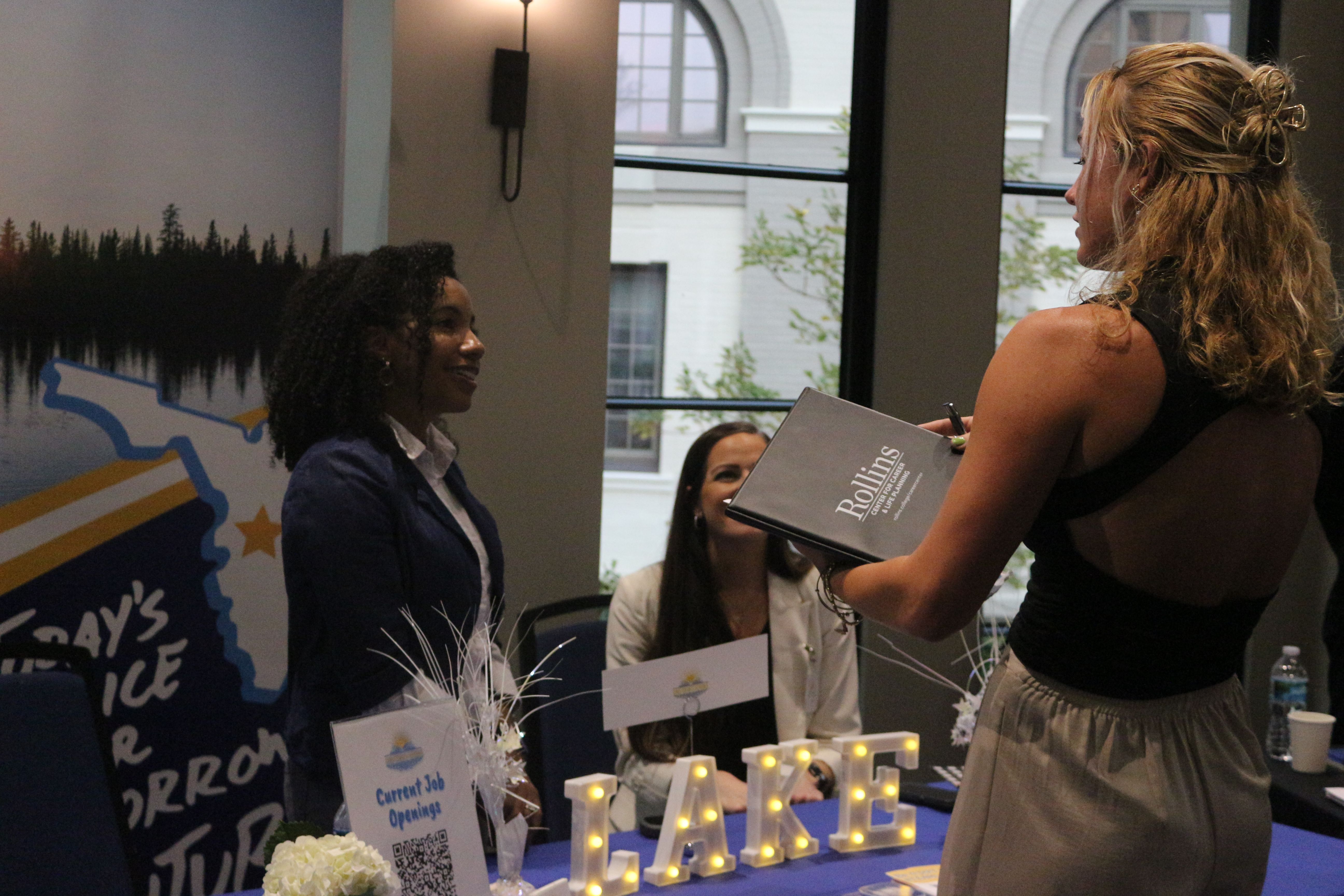 female student talking to employer at fair