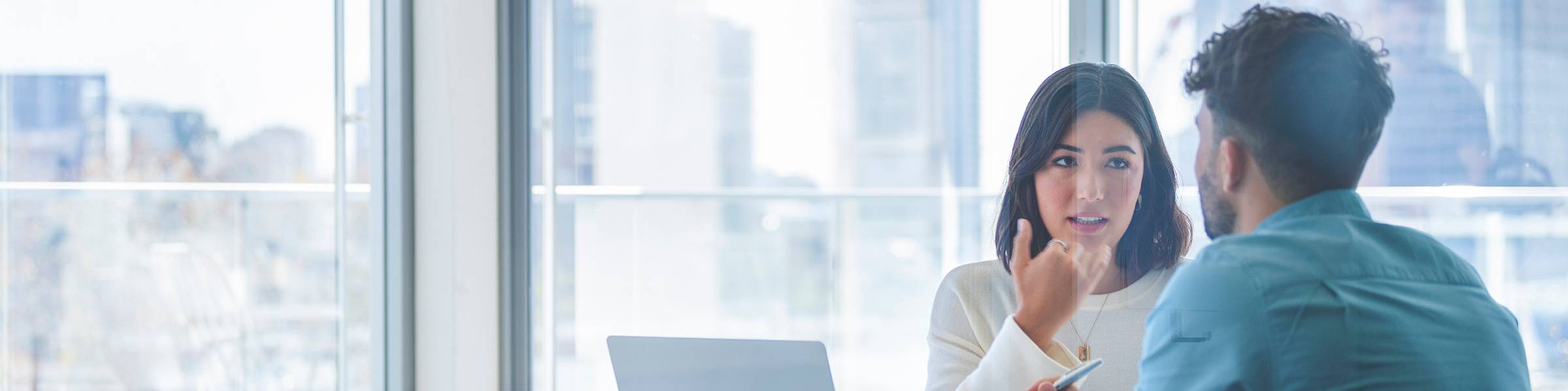 Two economists meet in a glass-walled conference room.