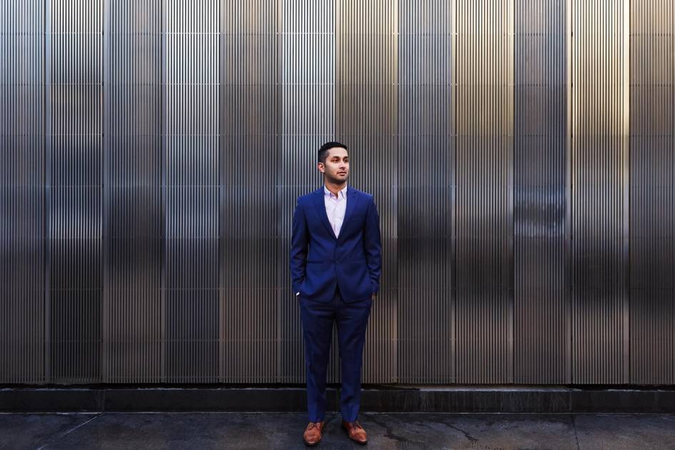 Aditya Mahara poses for a portrait against a metal wall in New York City.