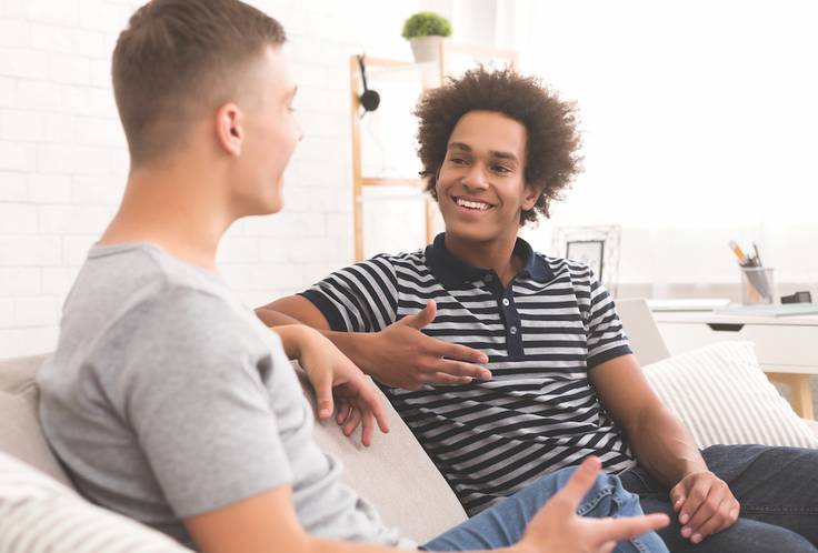 Two graduate students engage in conversation. 