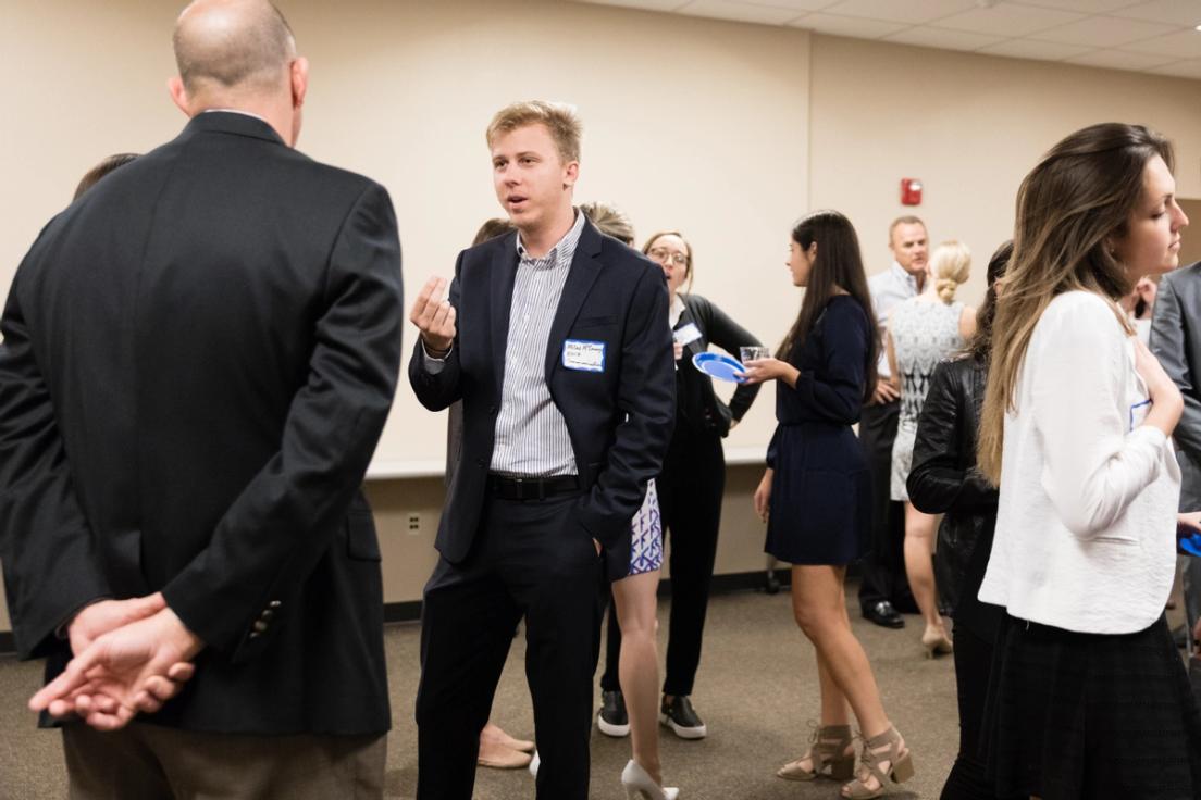 A group of students networking with business owners in the community.