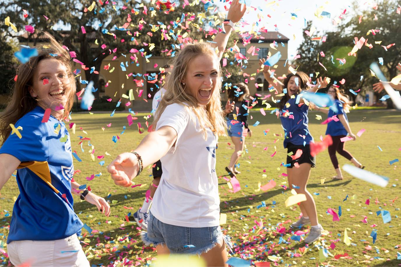 Rollins students celebrating on Mills Lawn with confetti.